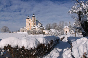 Closer view of Maria Plain pilgrimage church seen from a snowy path in winter.