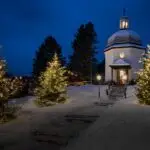 Silent Night Chapel by night in Oberndorf, Austria, softly illuminated under a starlit winter sky.