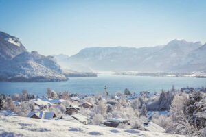 View from the St. Gilgen viewing platform overlooking snowy Lake Wolfgang and surrounding mountains.