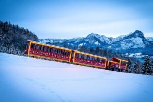 The Advent Train on Schafberg in the evening, with mountains and Lake Wolfgang in the background.