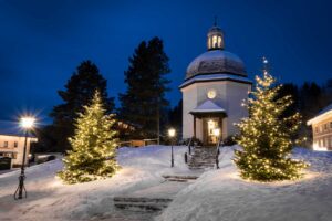 Silent Night Chapel at night, covered in snow, creating a peaceful winter scene.