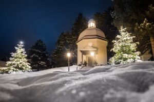 Silent Night Chapel in Oberndorf, Austria, with lights illuminating its classic structure.