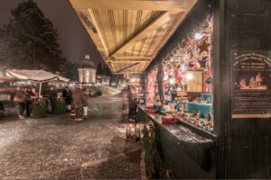 Christmas market stall in Oberndorf decorated with holiday lights and festive ornaments.