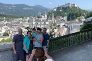 amily taking photos with the backdrop of Salzburg’s historic center and Hohensalzburg Fortress