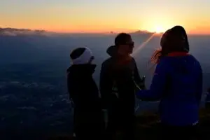 Three people enjoying the sunset from Gaisberg, overlooking Salzburg and the Bavarian Alps.