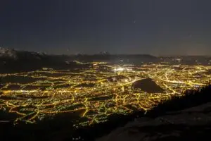 Nighttime view of Salzburg’s city lights from Gaisberg, with the Bavarian Alps in the background.