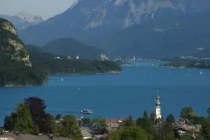 Lake Wolfgang viewed from a scenic viewpoint, with blue waters, alpine scenery, and St. Wolfgang visible at the far end.